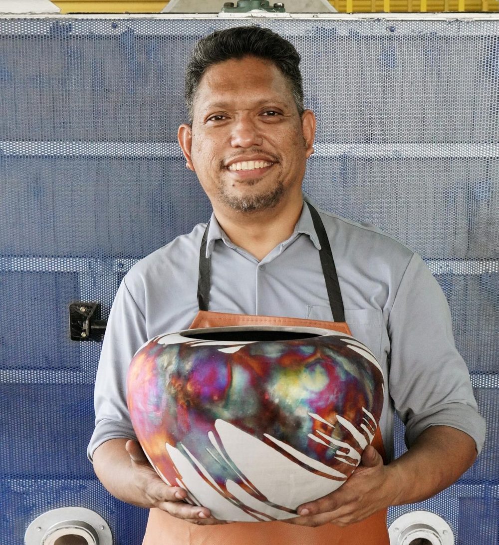 Adil Ghani, founder of RAAQUU and master ceramic artist, holding a raku vase